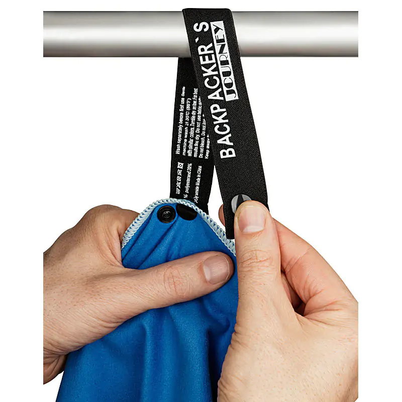 Detailaufnahme eines Tuches, im Produktbild soll die Verschließbarkeit des Aufhängers mittels Druckknopf gezeigt werden. Anwendungsfoto, Handtuch mit Aufhängelasche und Druckknopf